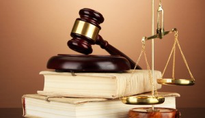 Golden scales of justice, gavel and books on brown background Golden scales of justice, gavel and books on brown background